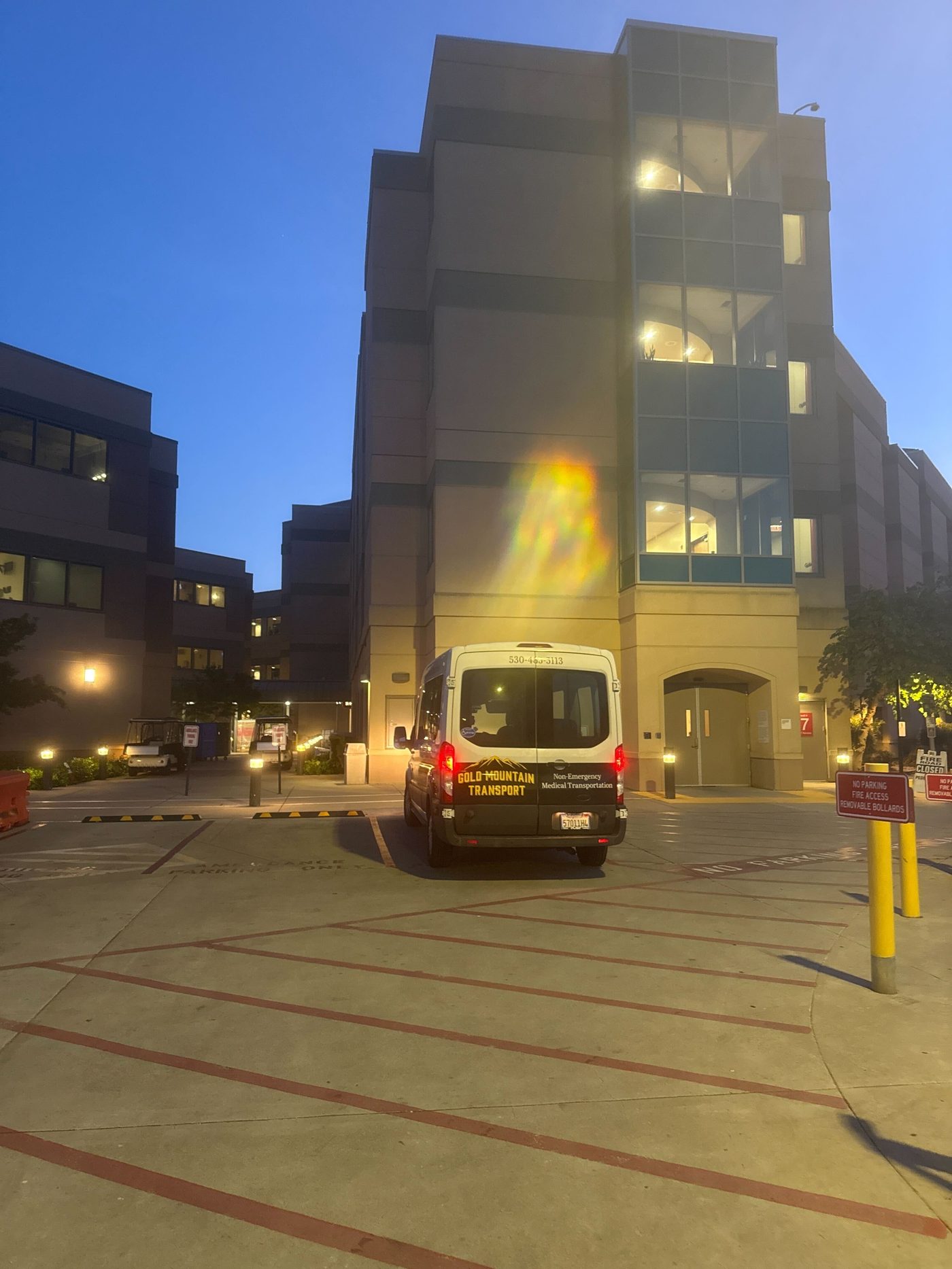 Gold Mountain Transport van at a hospital entrance at night for a discharge