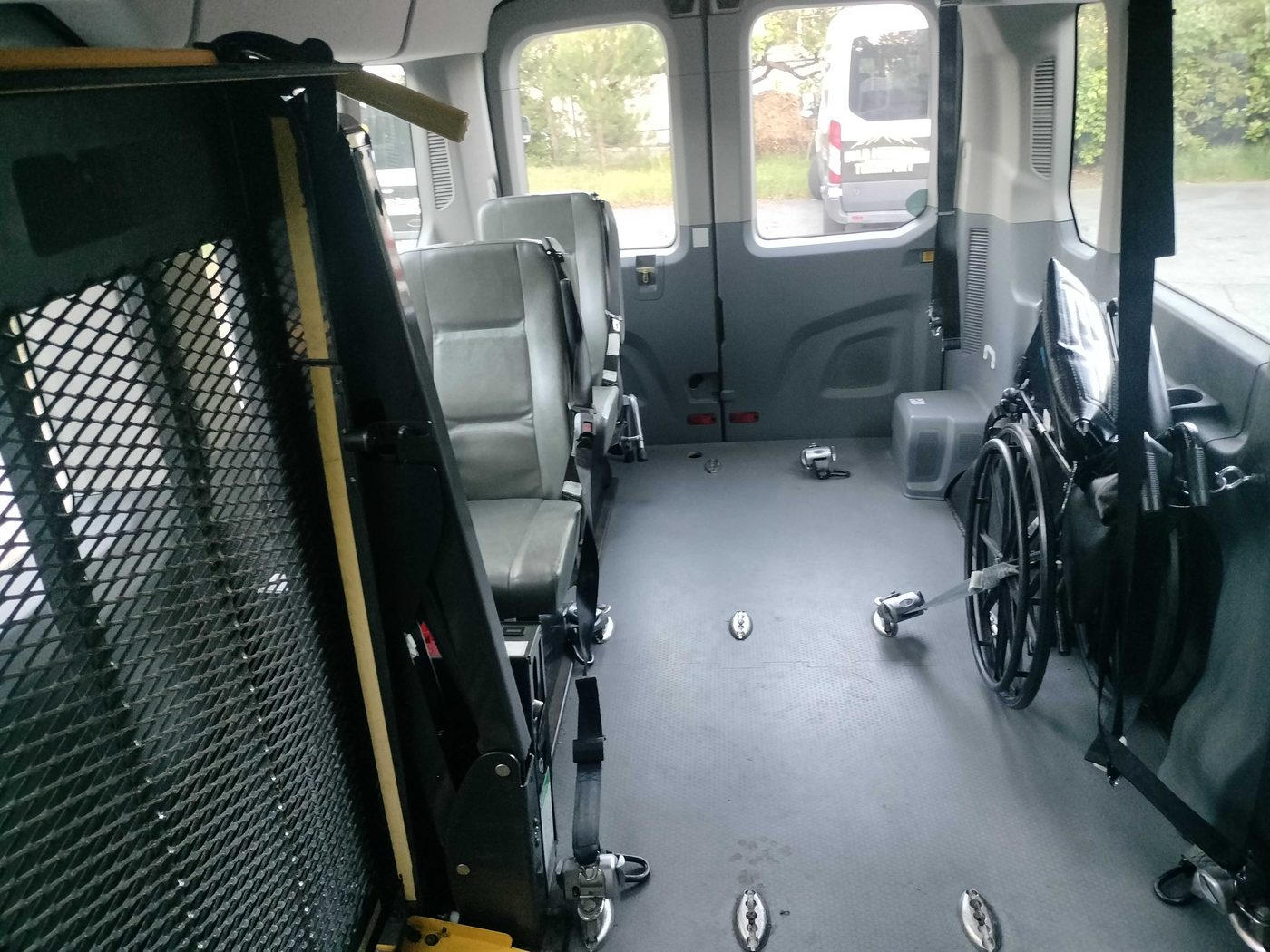 Interior of a wheelchair-accessible van with floor tie-downs and securement straps